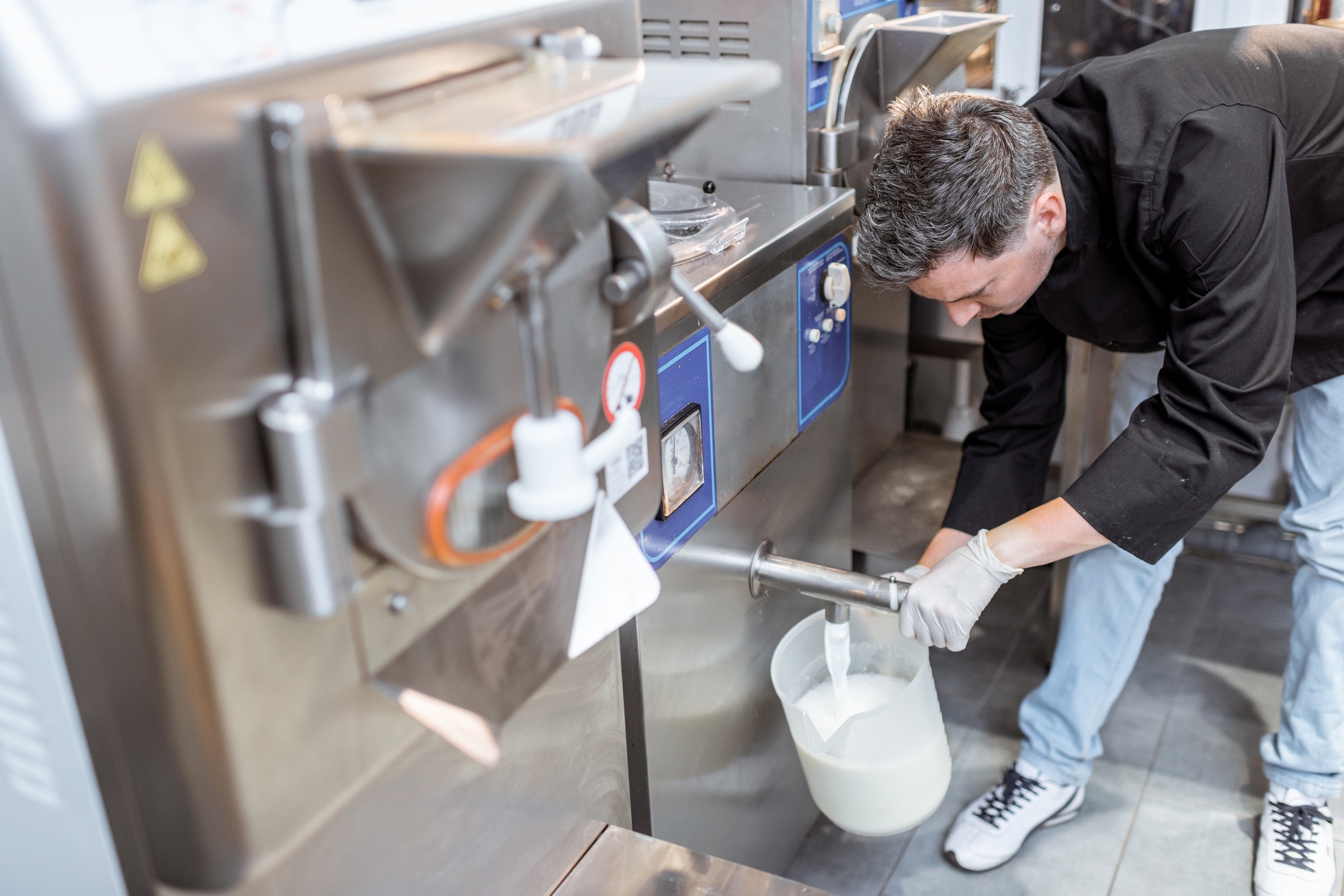 Chef pouring pasteurized milk from the pasteurizer